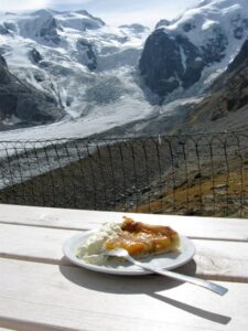 Aprikosentorte (apricot torte) with fresh whipped cream fronting alpine glacier, near Pontresina, Switzerland