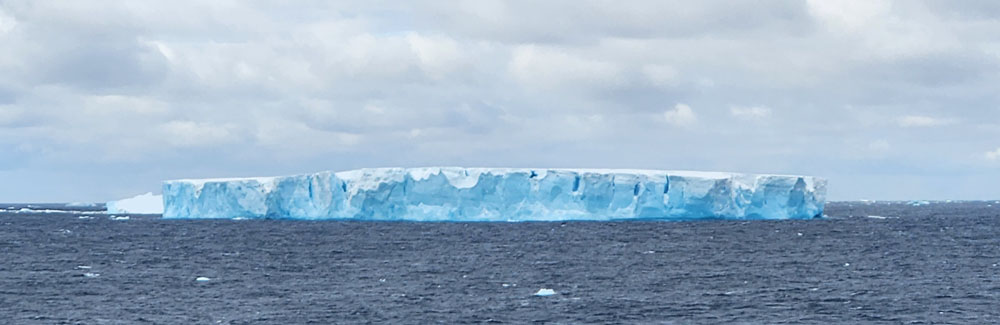 A large blue ice shelf in the ocean.