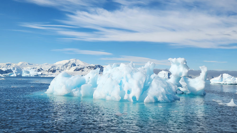 A large blue ice shelf in the ocean.