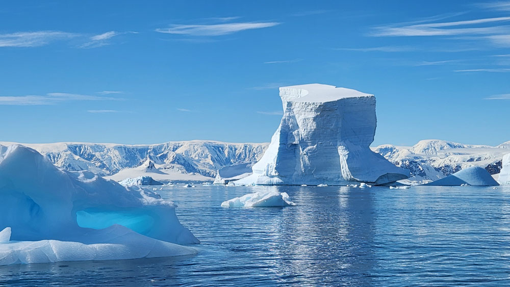 A large blue ice shelf in the ocean.