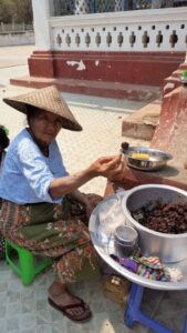 Woman offering homemade tamarind snack near Mandalay, Myanmar